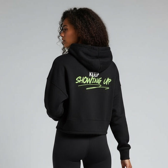 Person wearing a black hoodie with text and leggings on a gray background