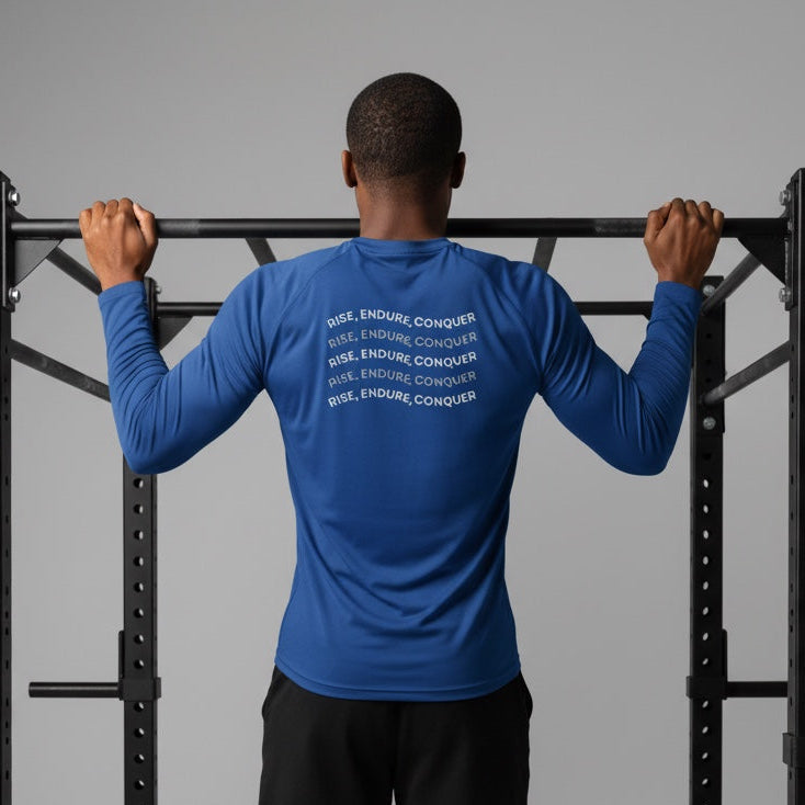 Person wearing a blue athletic shirt with text on the back, standing on a black pull-up bar against a gray background.
