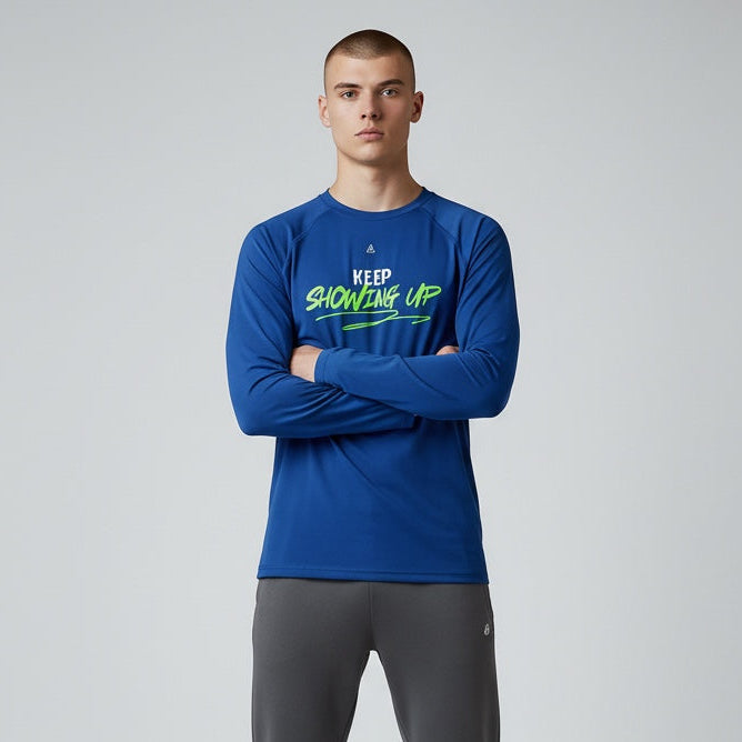 Man wearing a blue long-sleeve shirt and gray pants on a light gray background